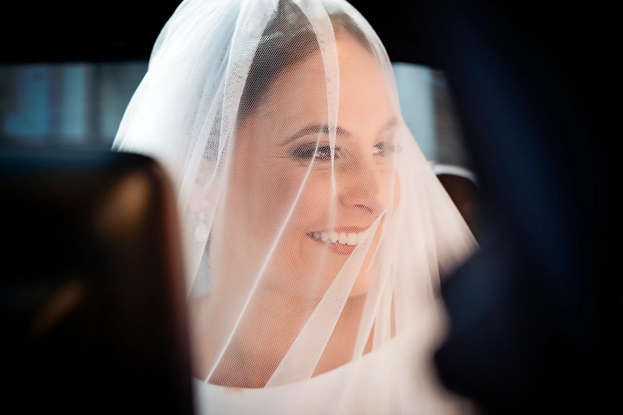 Novia sonriendo bajo el velo