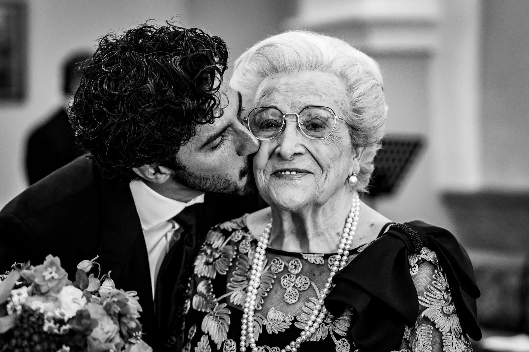 Novio besando a su abuela, en blanco y negro