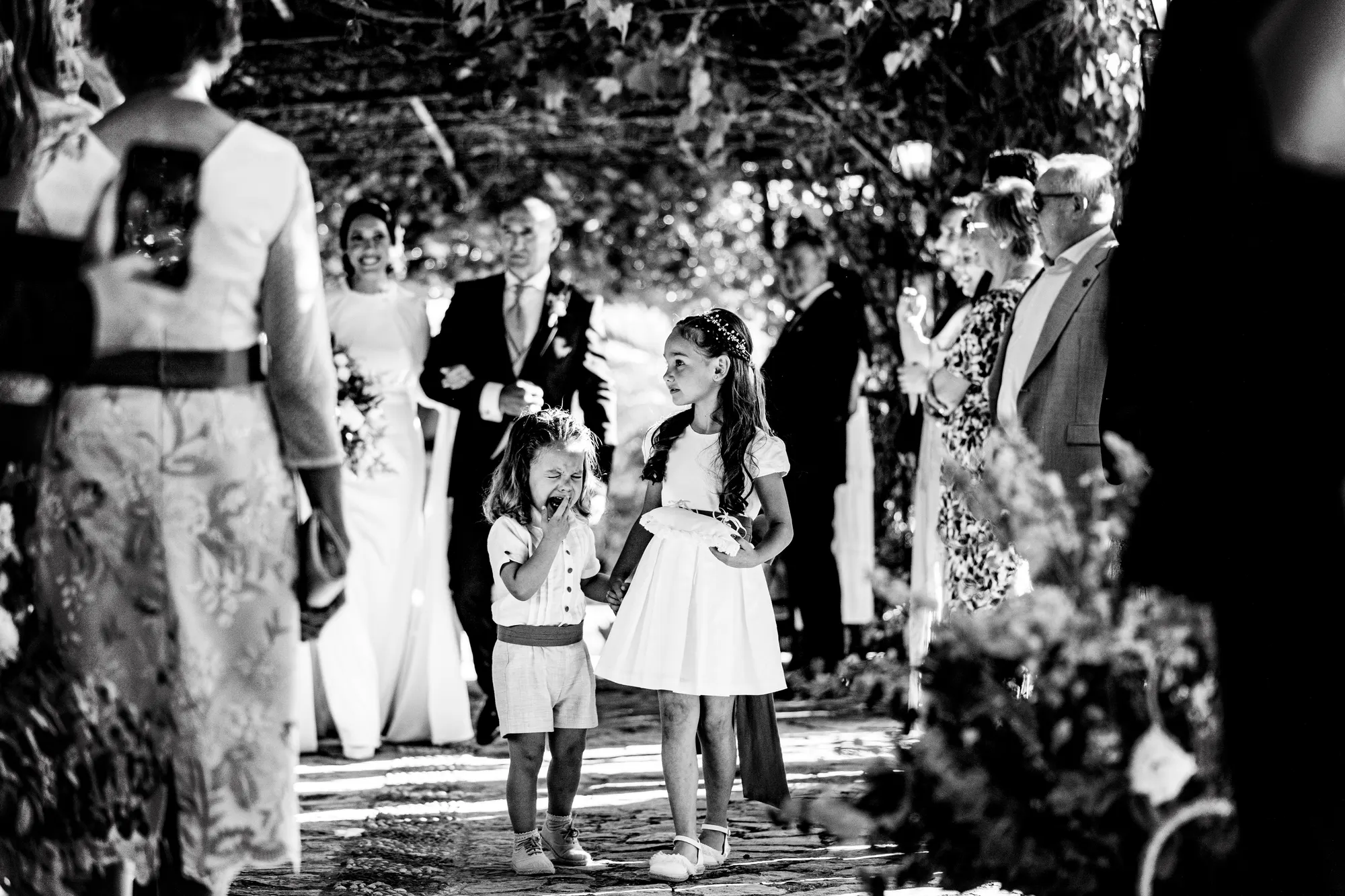 Salida de los novios entre niños e invitados, en blanco y negro