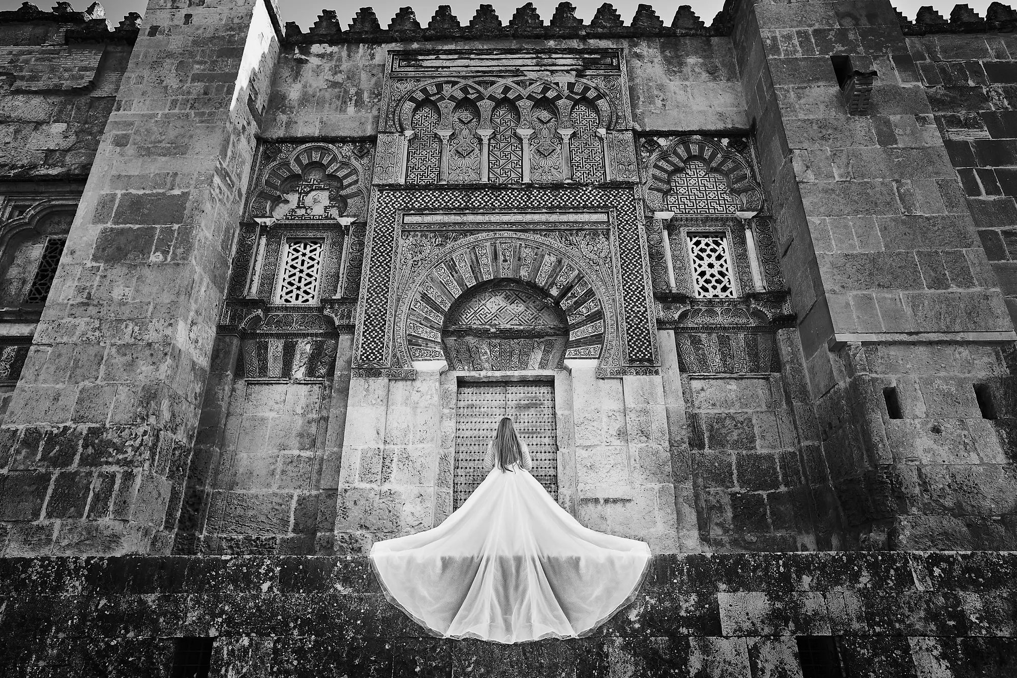 Novia con la cola del vestido extendida ante la Mezquita de Córdoba