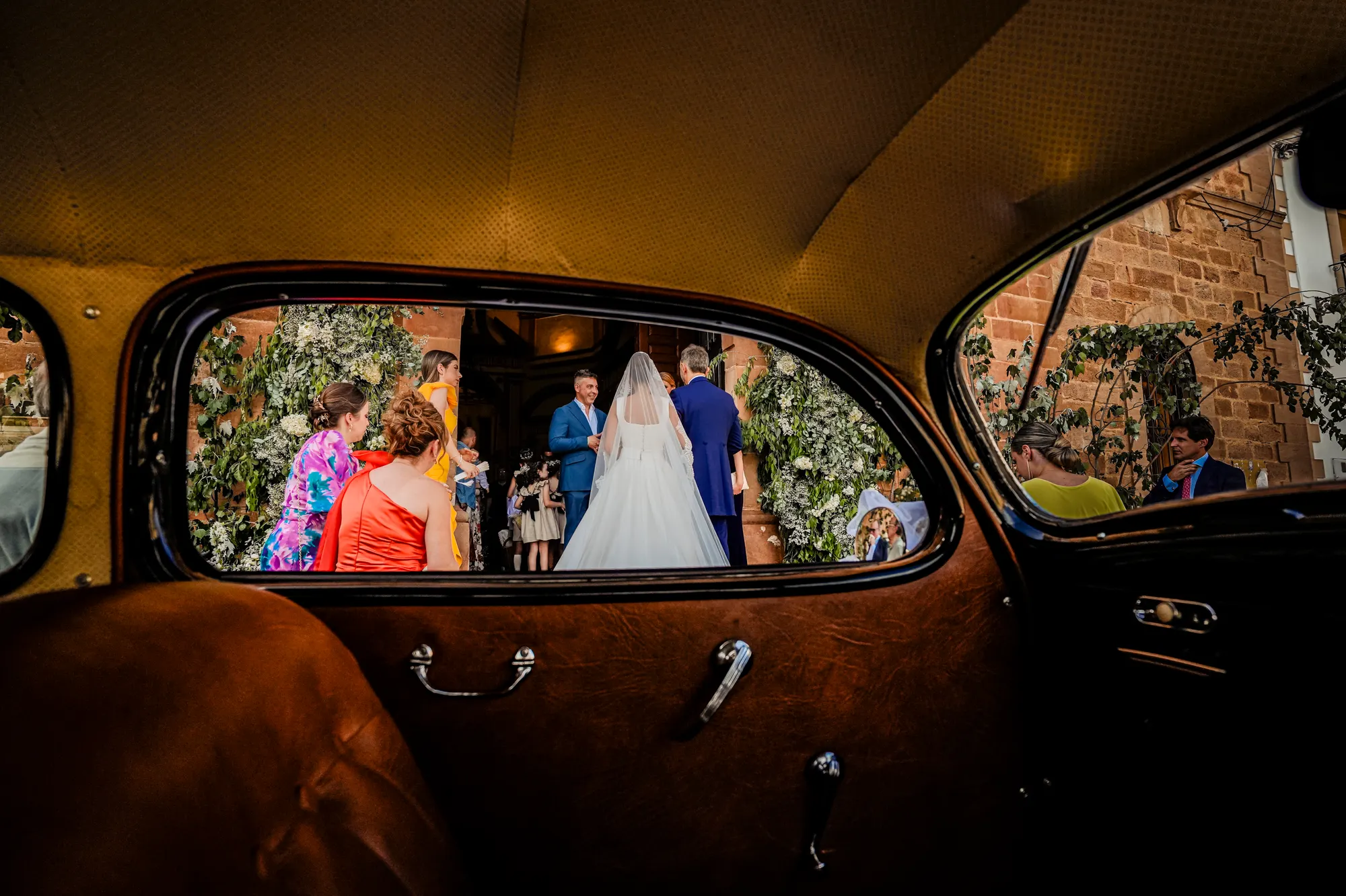 Los novios vistos a través de la ventanilla de un coche clásico