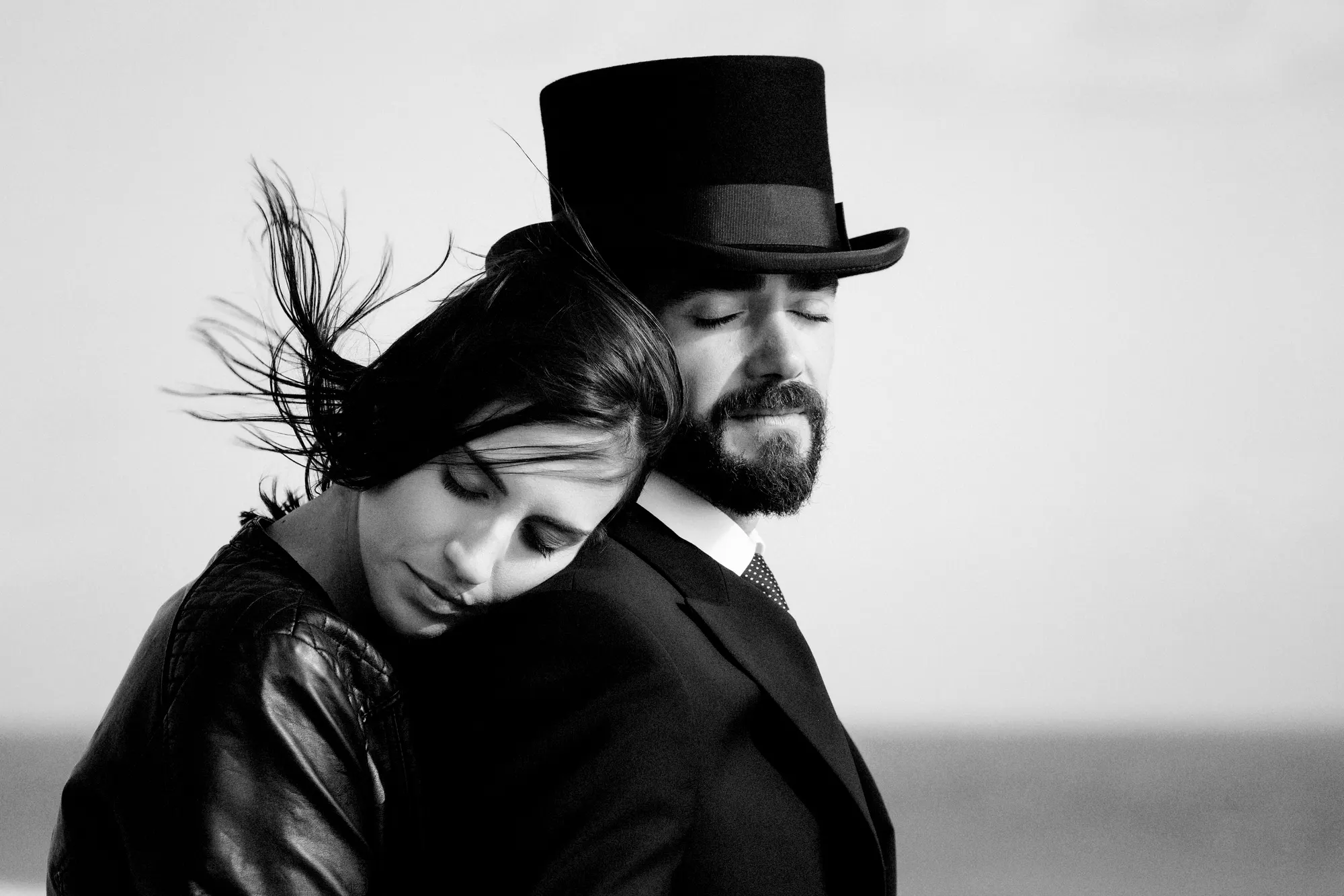 Pareja abrazada con sombrero de copa, en blanco y negro