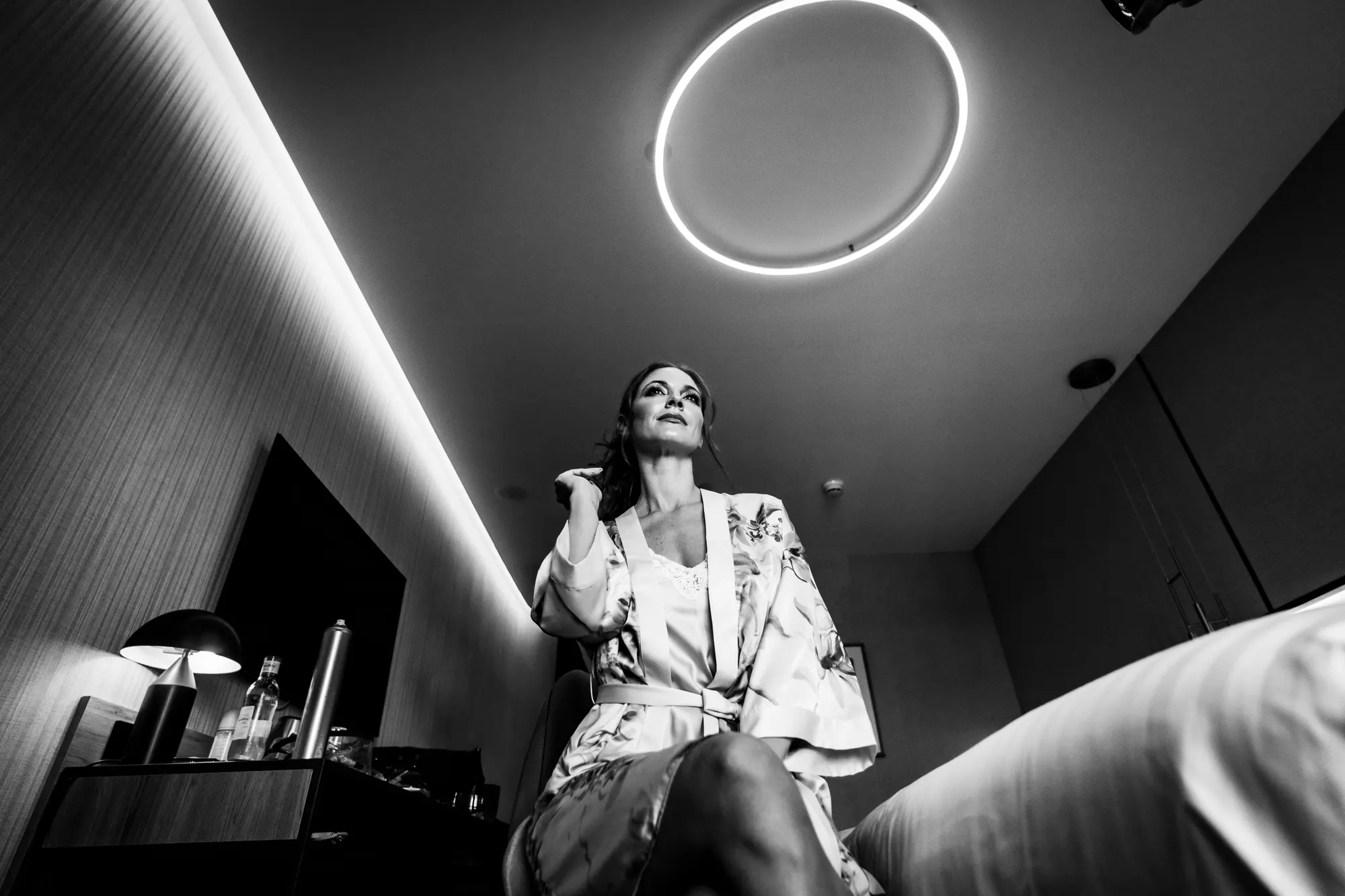 Novia en bata durante los preparativos bajo un anillo de luz