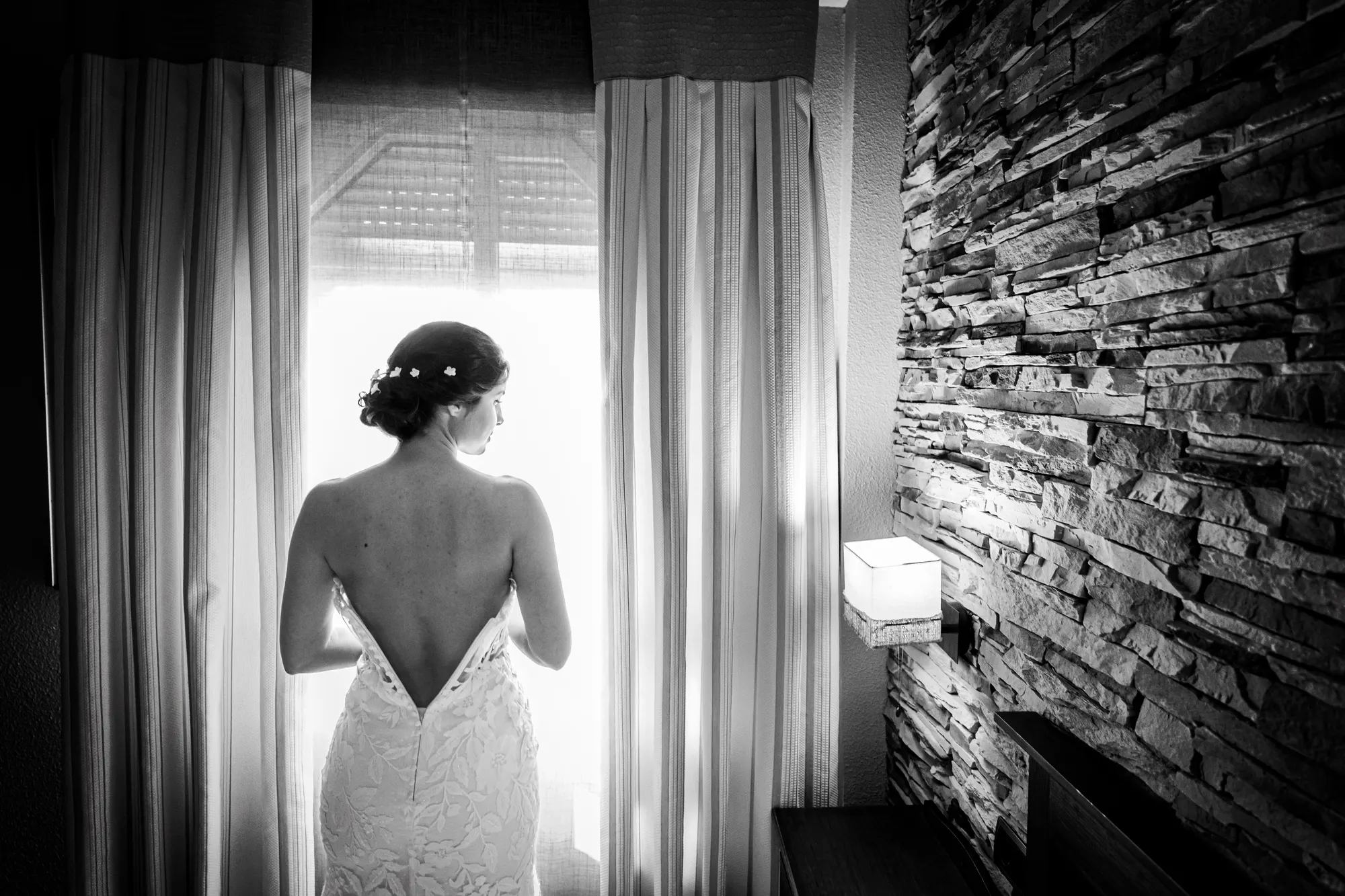 Novia de espaldas junto a la ventana, en blanco y negro