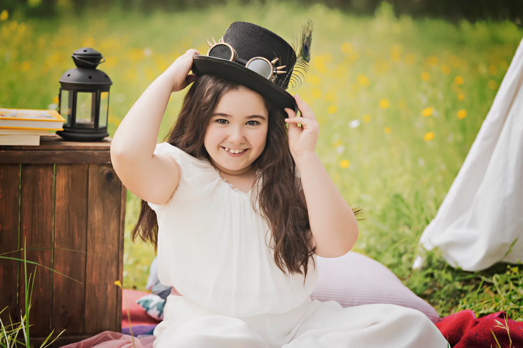 Niña de comunión con sombrero de copa en un picnic en el campo