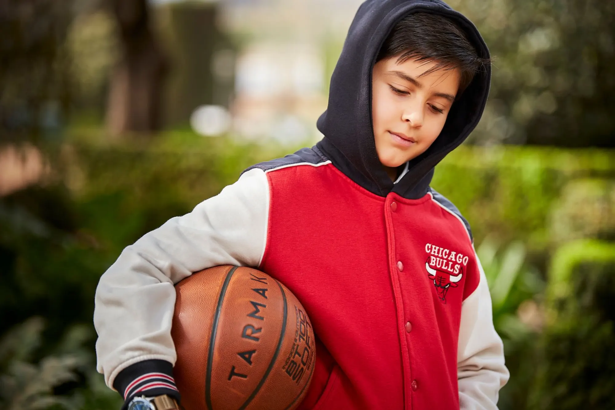 Niño con sudadera y balón de baloncesto
