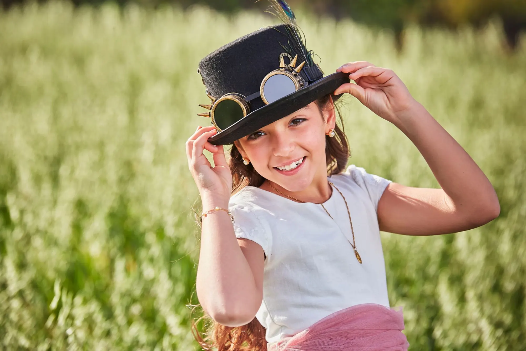Niña con sombrero de copa en un campo de trigo