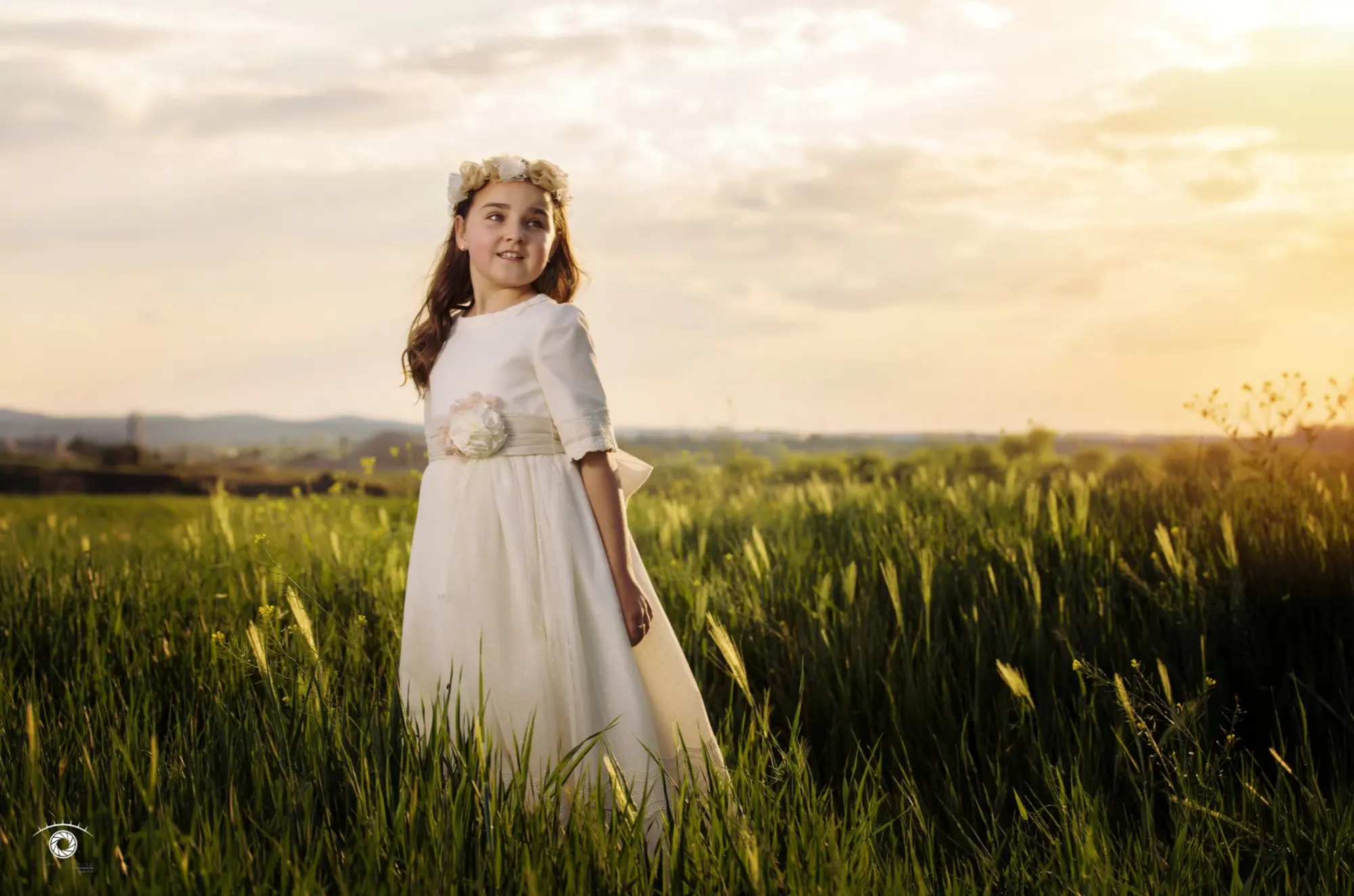 Niña de comunión en un campo al atardecer
