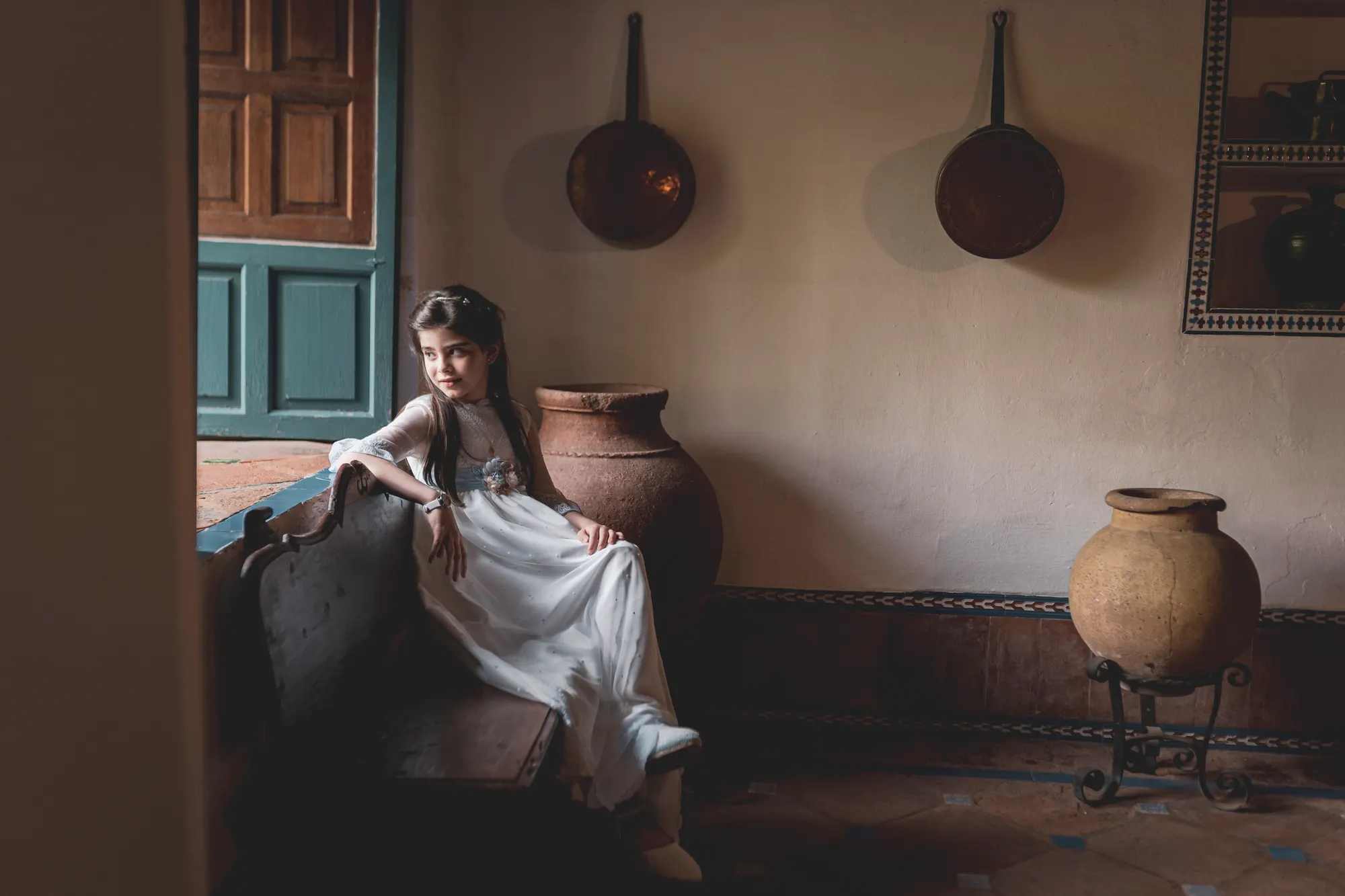 Niña de comunión sentada en una casa tradicional