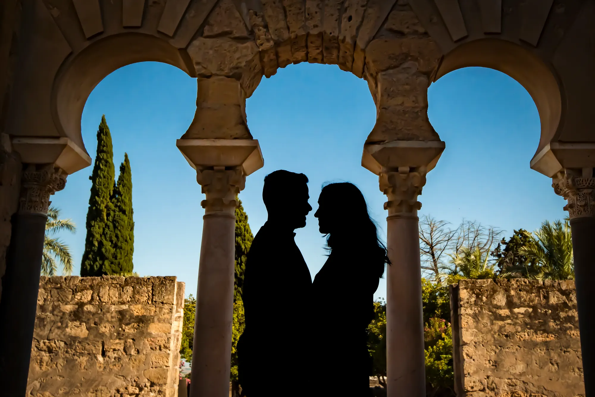 Silueta de la pareja bajo unos arcos de piedra